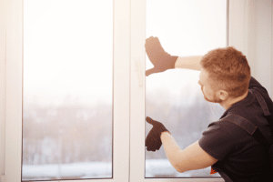 man installing new window during winter