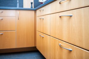 Warm natural wood tone kitchen cabinets with sleek silver bar handles